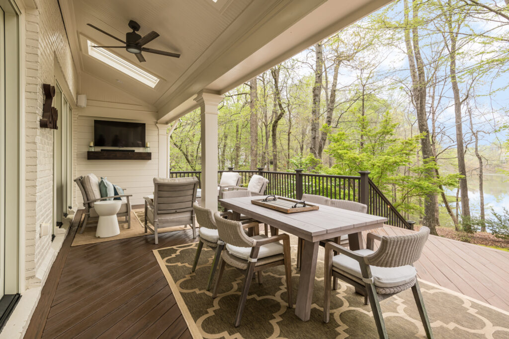 a covered porch with a table and chairs