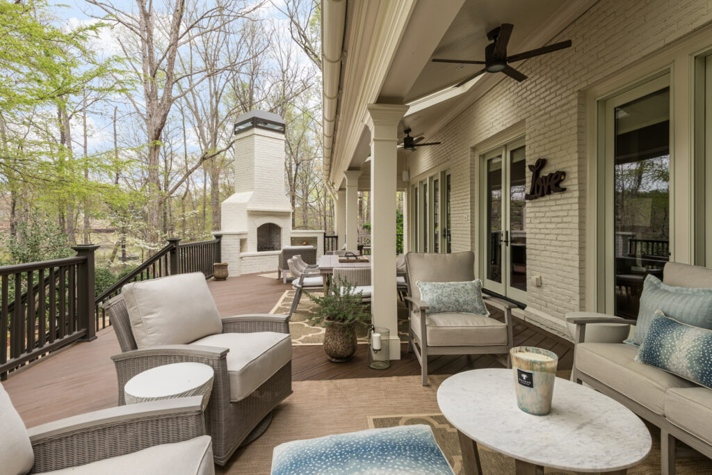 a covered porch with furniture and a fireplace