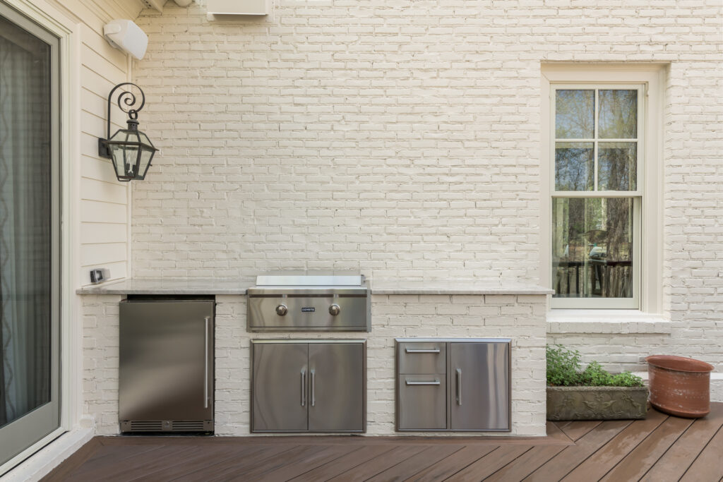 an outdoor kitchen with a grill on a deck