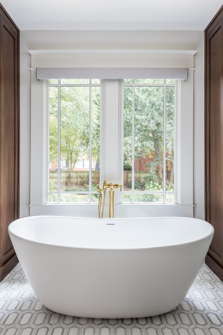 a large white bathtub in a bathroom next to a window