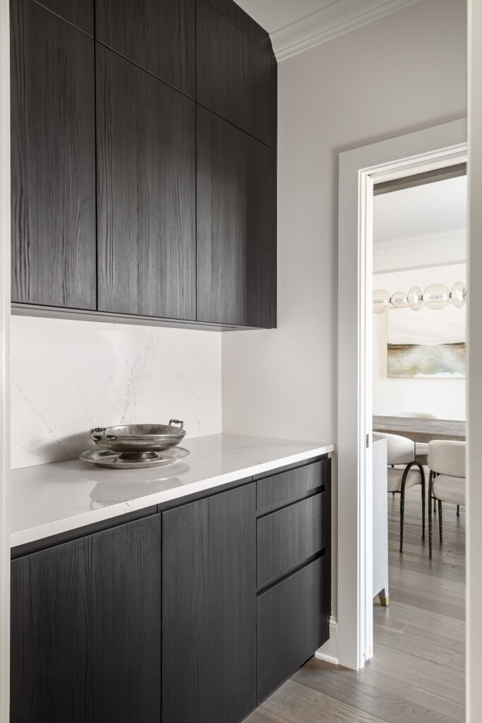 a kitchen with black cabinets and white counter tops