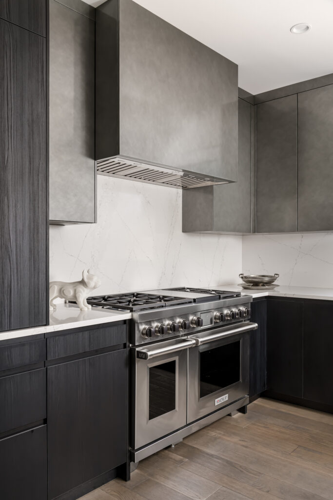 Minimalist Modern Kitchen vent hood a kitchen with a stove, oven, and cabinets