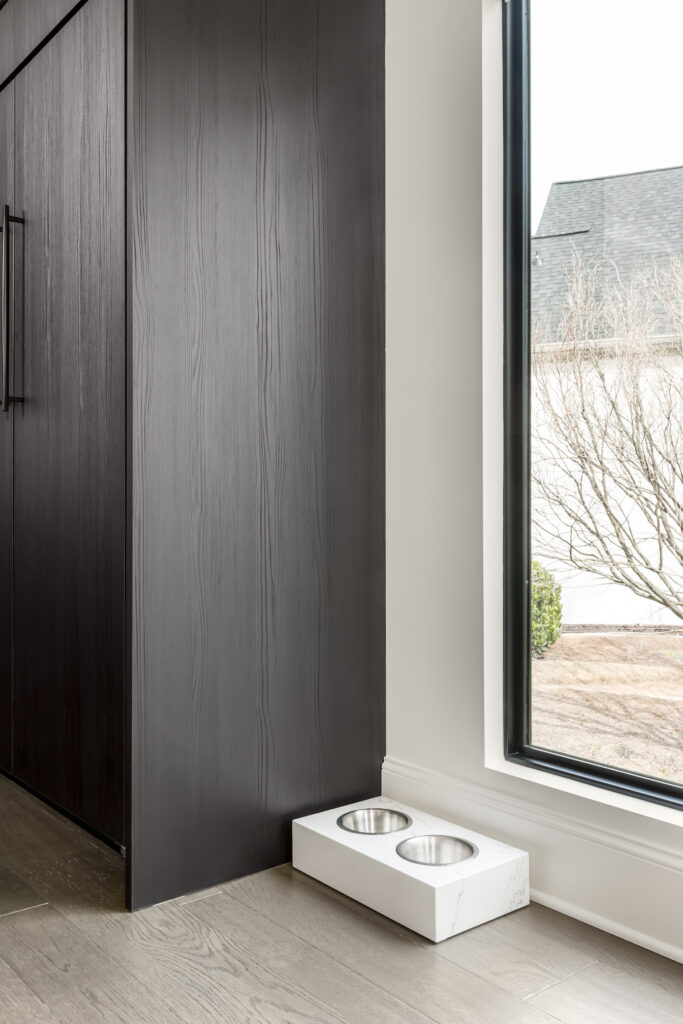 a dog bowl on the floor in front of a window