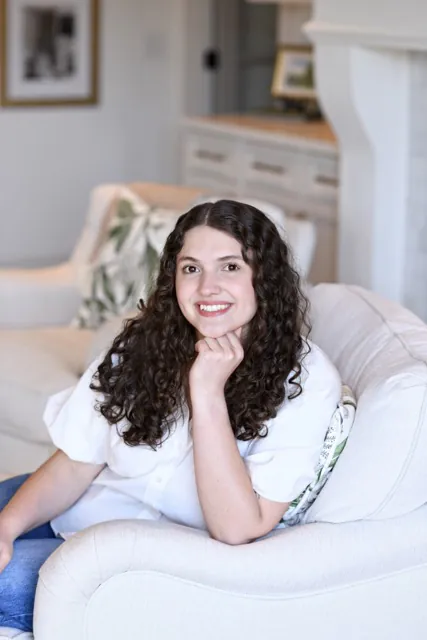 a woman sitting on a white couch in a living room