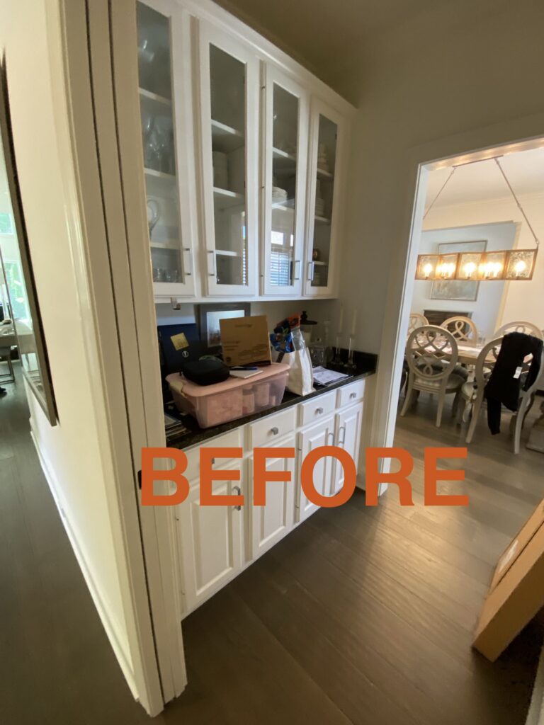 a kitchen with white cabinets and a black counter top