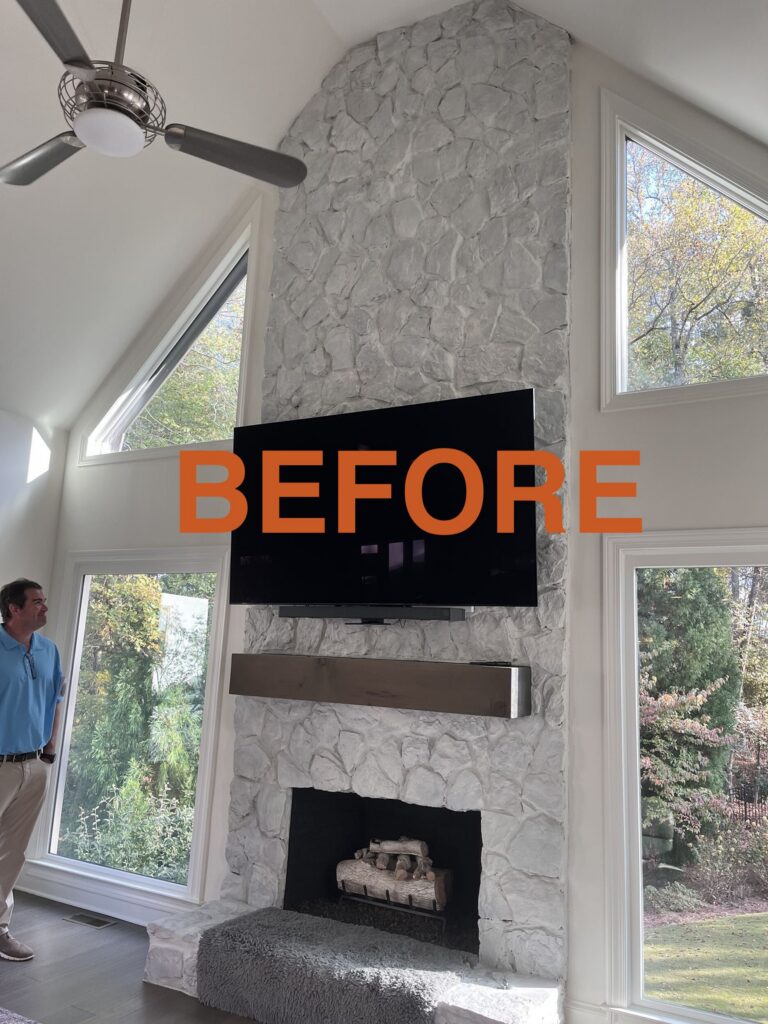 a man standing in a living room next to a fireplace
