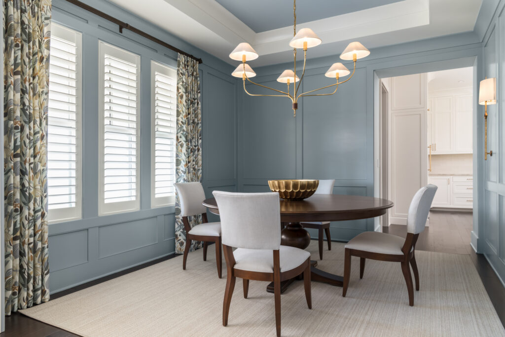 calming and cohesive color drenched blue dining room with a tray ceiling