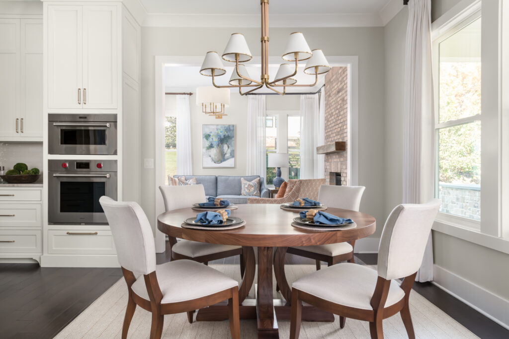 calming and cohesive breakfast nook with a round table and chandelier