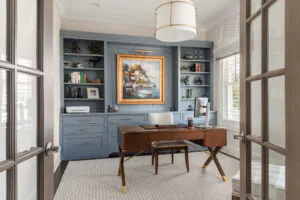a home office with built in bookcases and a desk