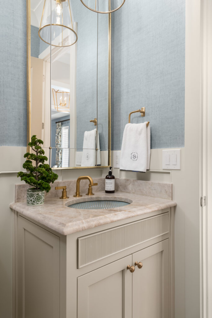 calming and cohesive powder room with a blue sink and textured wallpaper