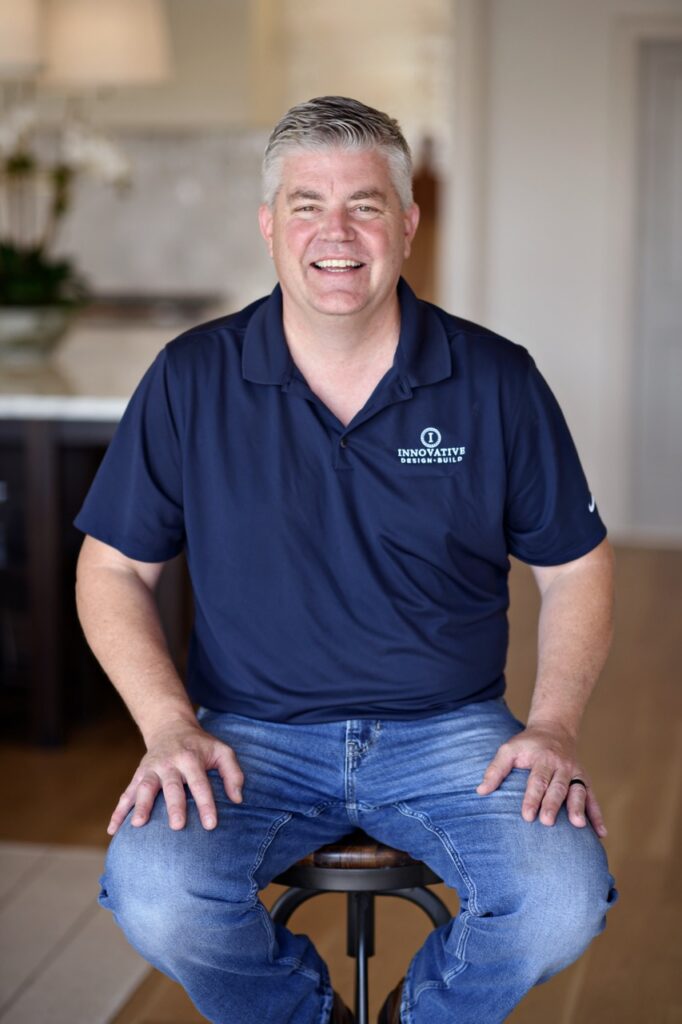 a man sitting on top of a stool in a kitchen