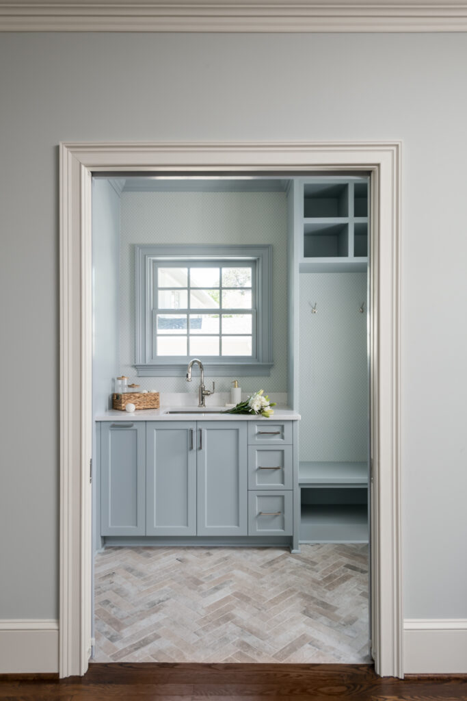 A laundry room-mudroom addition in Buckhead with double pocket French doors and a herringbone floor