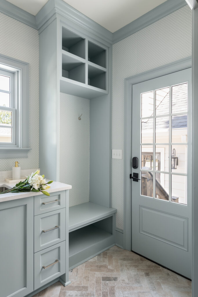 A laundry room-mudroom addition in Buckhead with landing zone built-ins including a bench, a sink, countertop space and cabinetry.