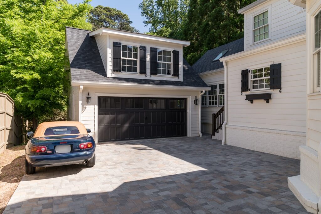 Exterior of a laundry room-mudroom addition in Buckhead that suits its cottage style. Also shown is a new carriage house and driveway.